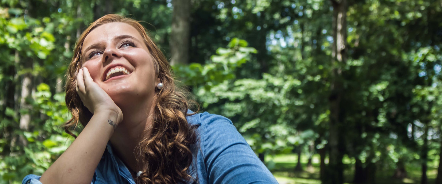 Une femme souriante regardant le ciel